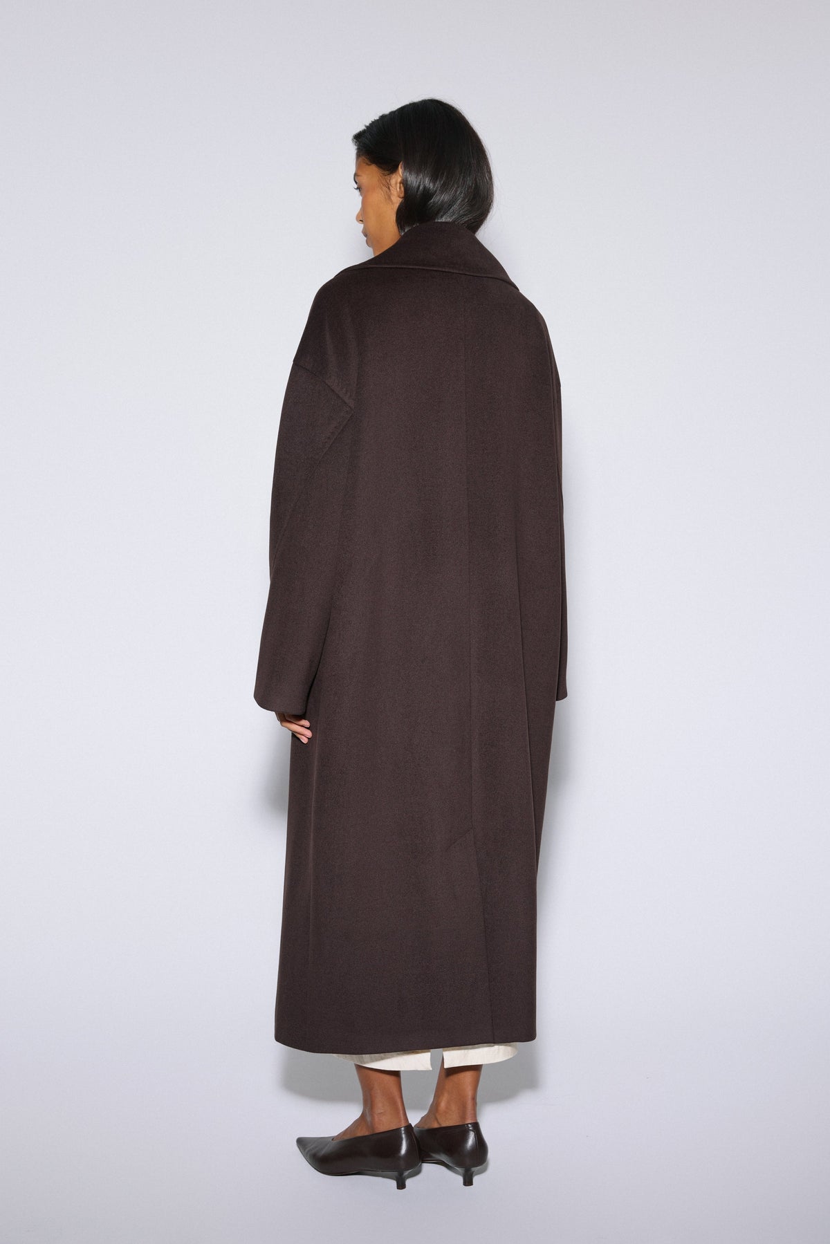 Long dark brown wool coat with waist belt and broad lapels, Estro.