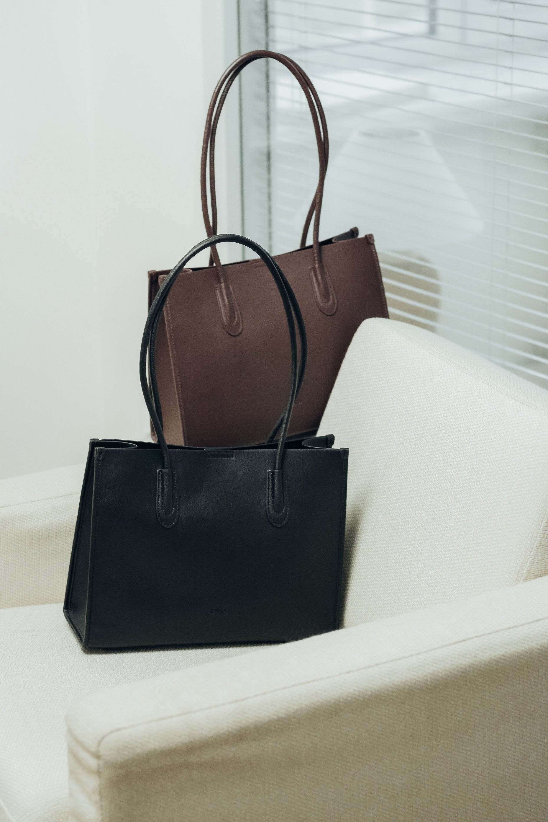 Two leather tote bags, one black and one brown.
