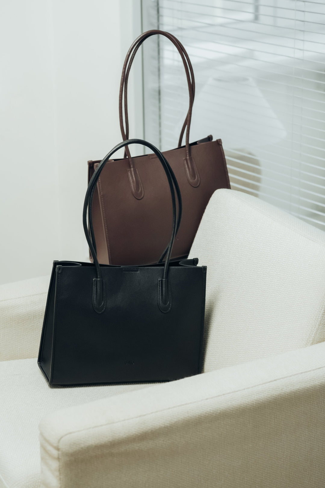 Two leather tote bags, one black and one brown.