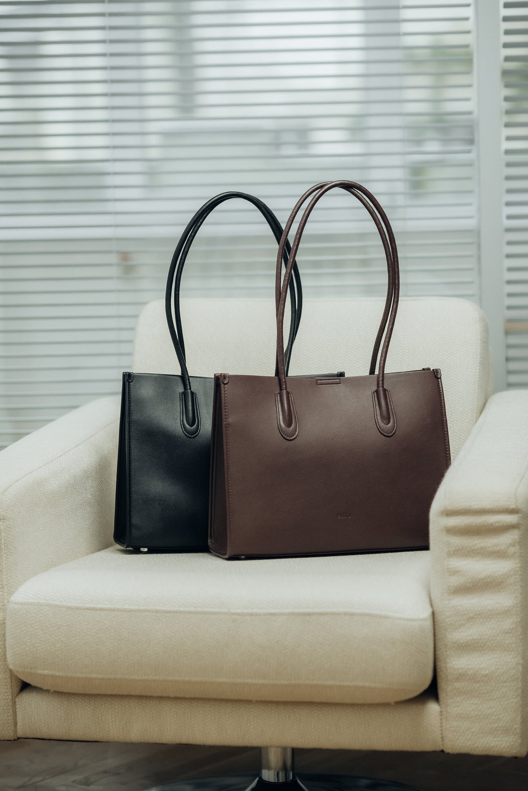 Two leather tote bags, one black and one brown.