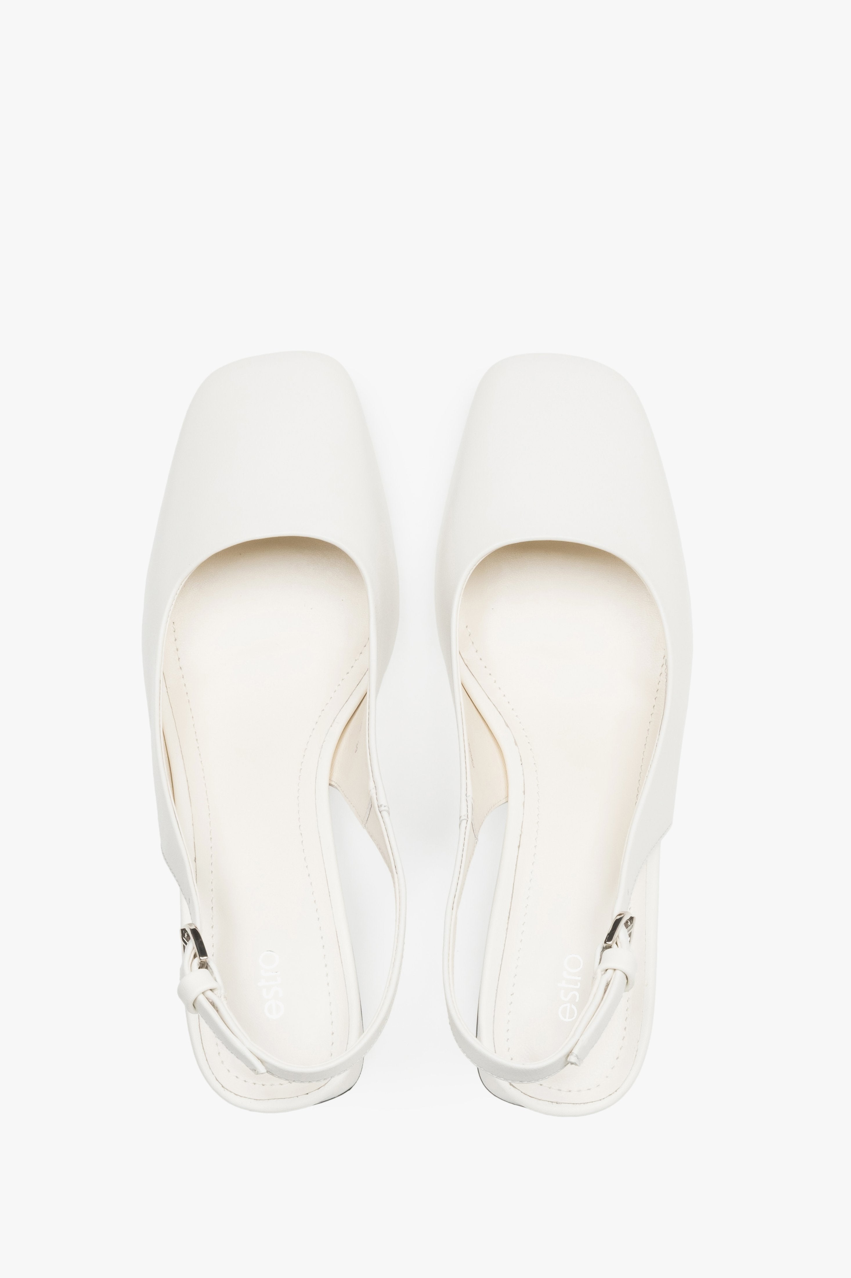 Close-up of the soft milky beige leather and silver-tone buckle on block-heel pumps.