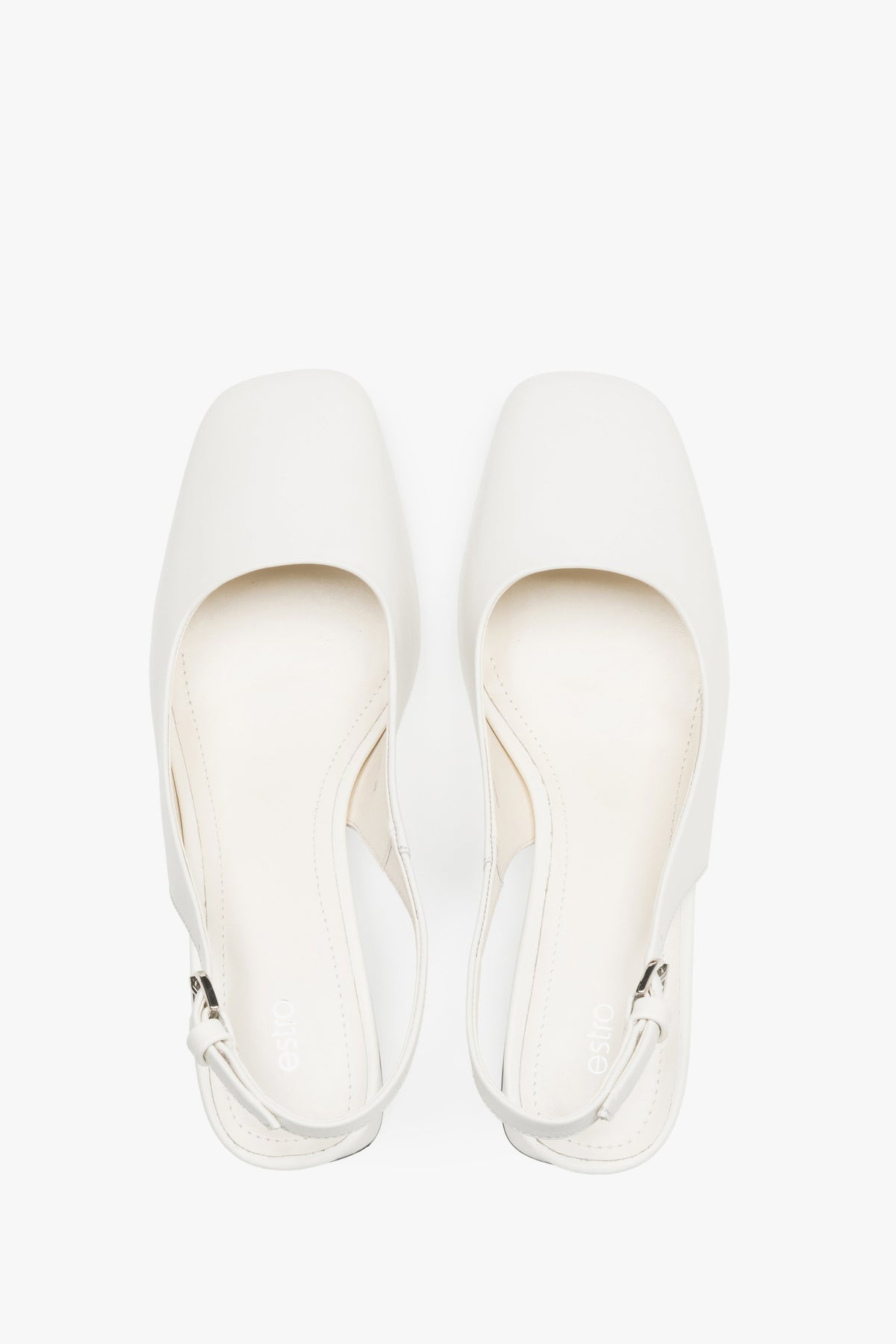 Close-up of the soft milky beige leather and silver-tone buckle on block-heel pumps.