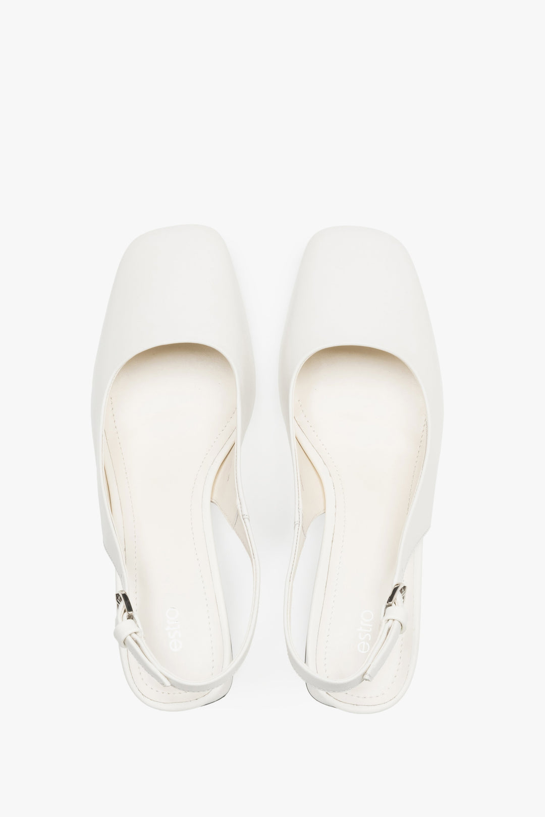 Close-up of the soft milky beige leather and silver-tone buckle on block-heel pumps.