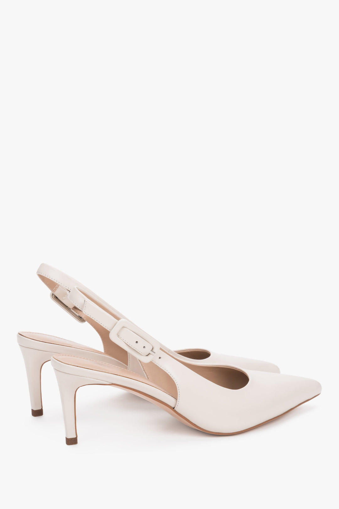 Close-up of the pointed toe and silver-tone hardware on milky beige leather pumps.