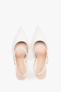 Close-up of the high-gloss milky beige patent leather and elegant strap detail.