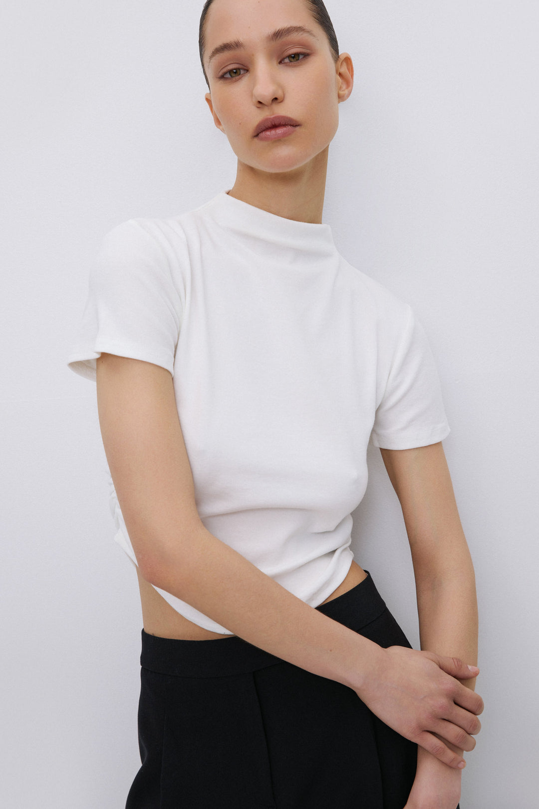 Model wearing milky beige T-shirt with ruched waist.