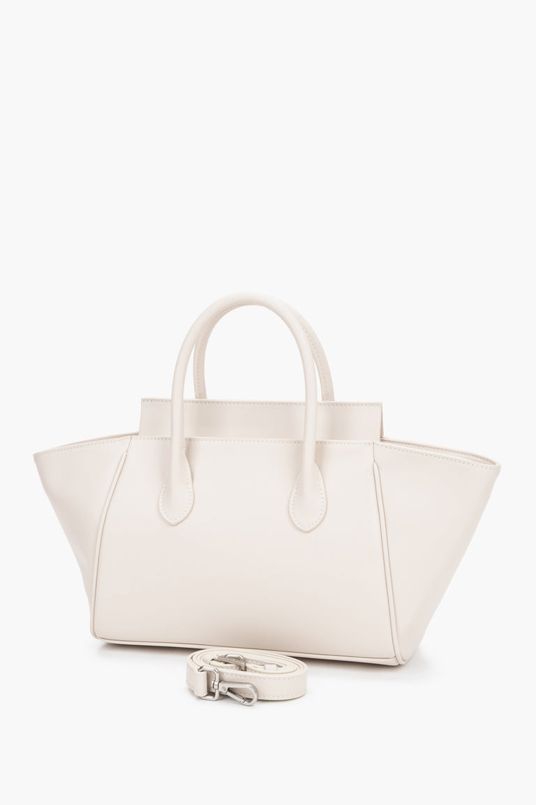 Milky beige women’s leather bag by Estro featuring a unique horizontal silhouette with wide trapeze-shaped sides and short handles.