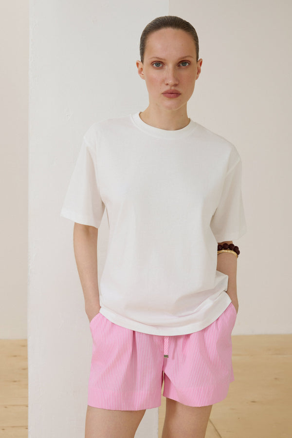 Model wearing milky white boxy-style cotton T-shirt.