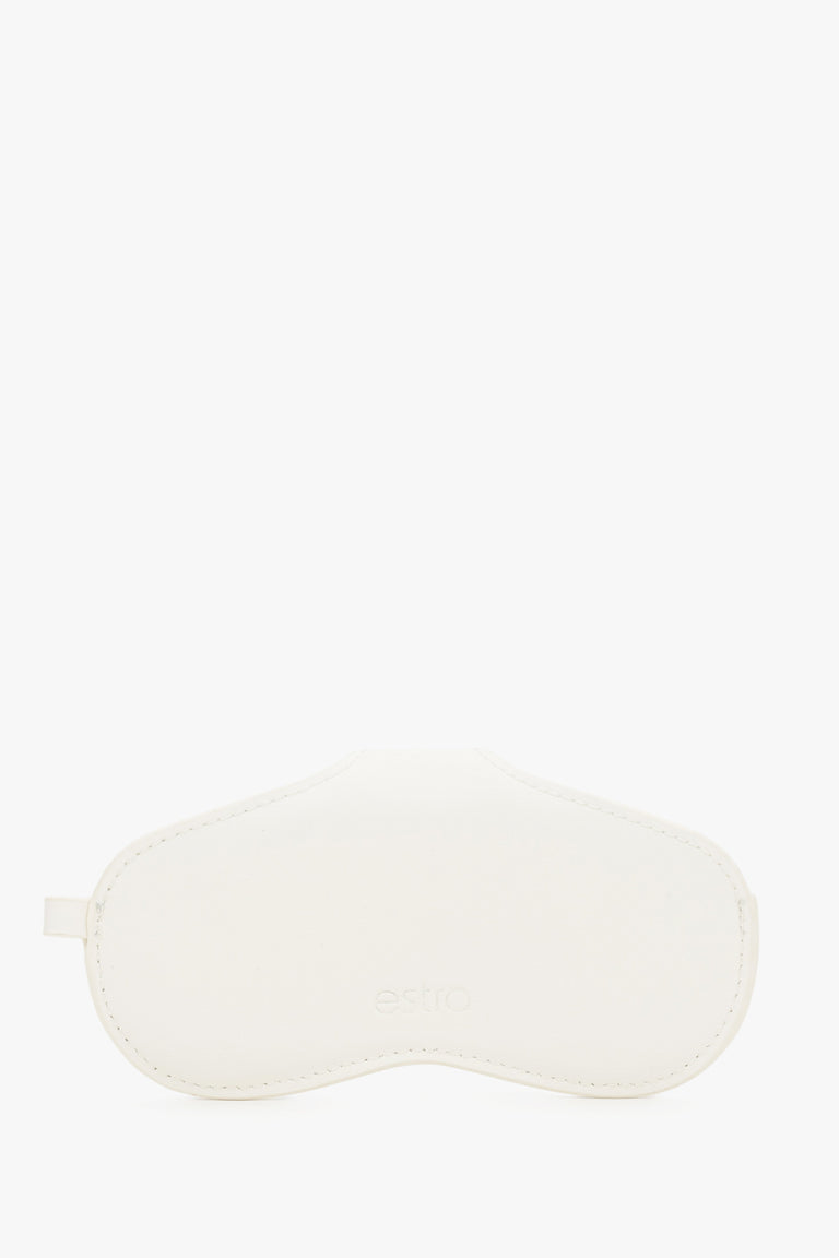A side view emphasizing the slim, compact profile of the white case and its precise, tonal stitching.
