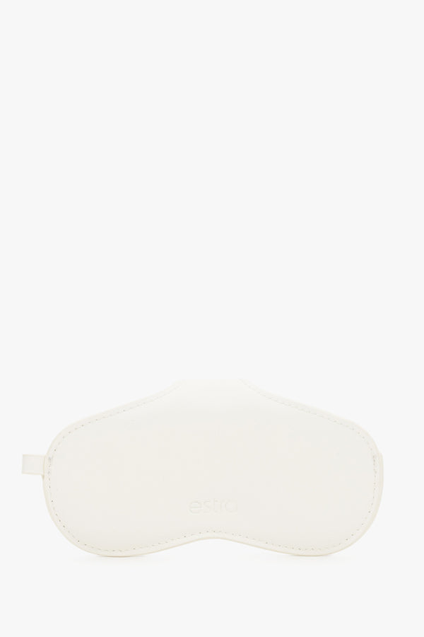 A side view emphasizing the slim, compact profile of the white case and its precise, tonal stitching.