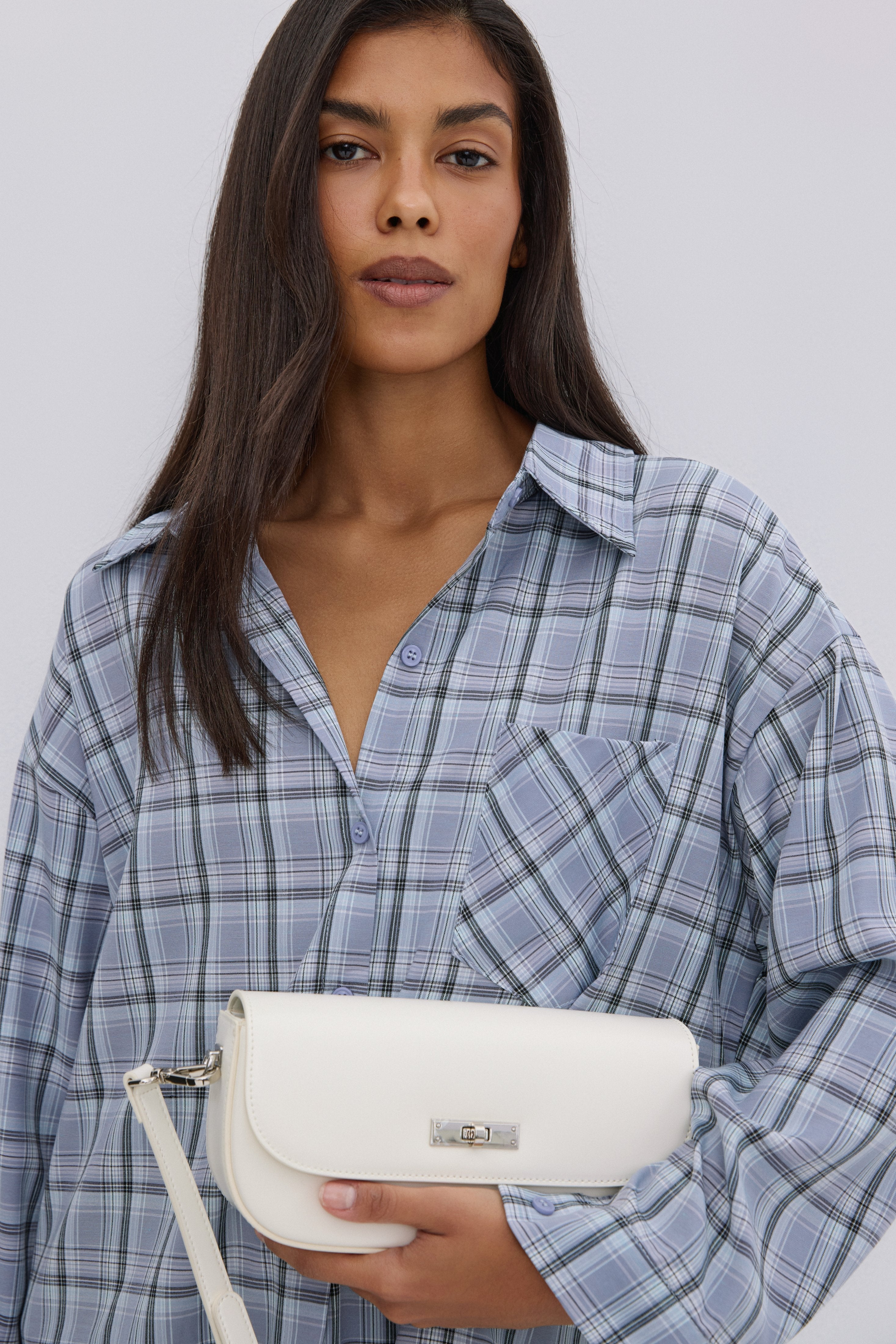 Women's oversized blue checkered button-up shirt.