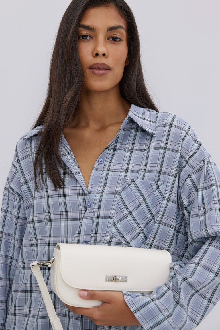 Women's oversized blue checkered button-up shirt.