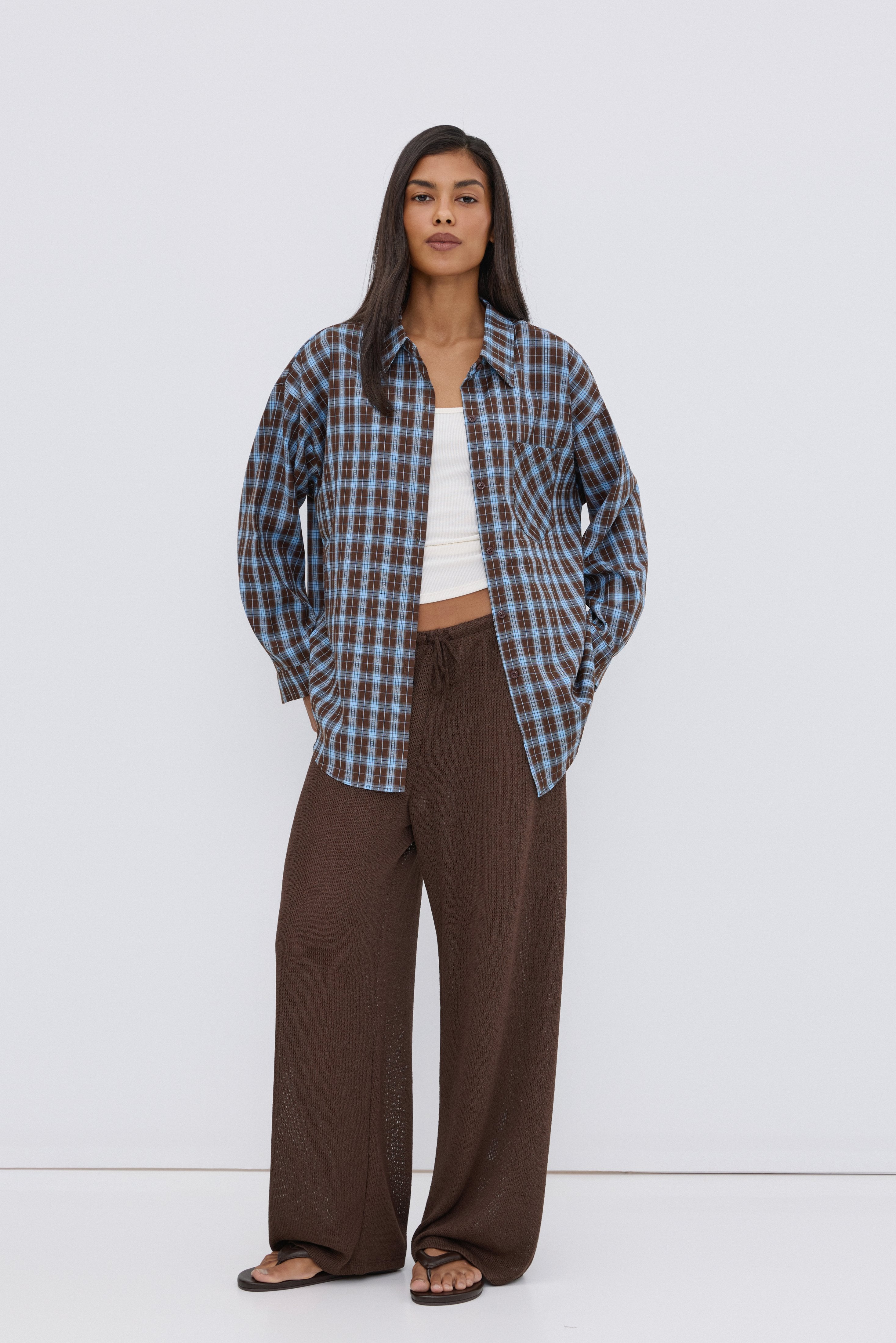 Women's oversized button-up shirt in blue and brown plaid.