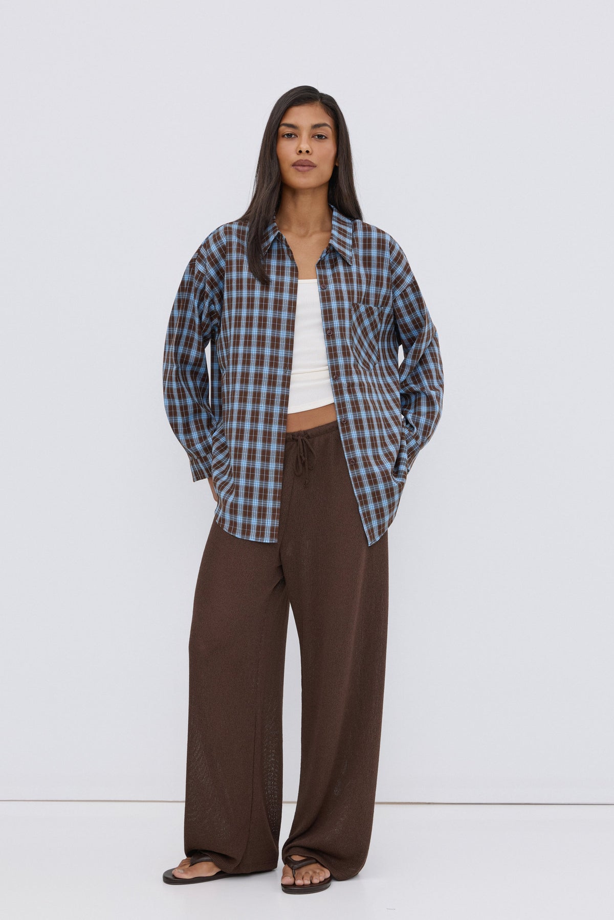 Women's oversized button-up shirt in blue and brown plaid.