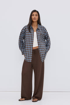 Women's oversized button-up shirt in blue and brown plaid.