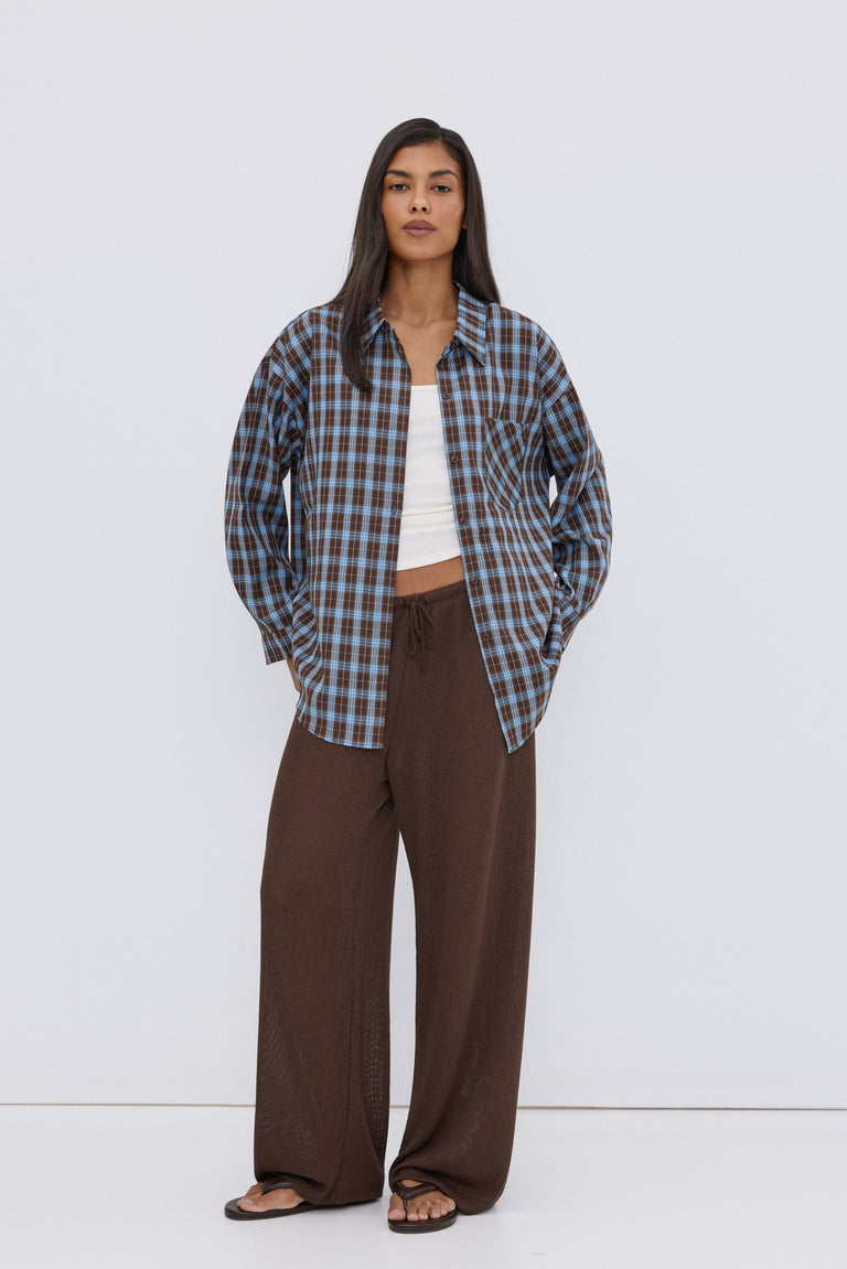 Women's oversized button-up shirt in blue and brown plaid.