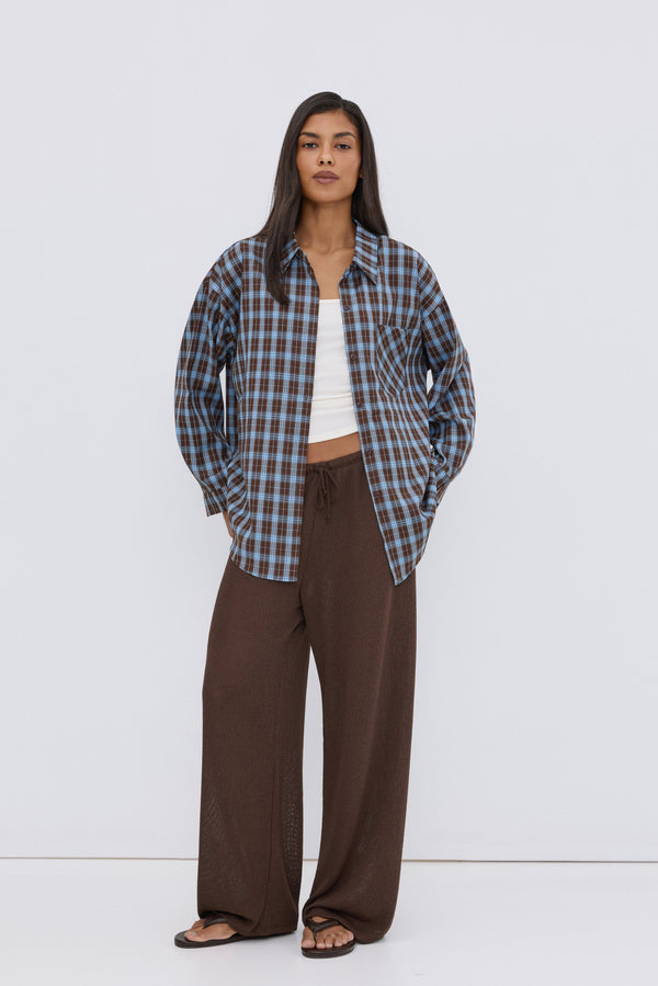 Women's oversized button-up shirt in blue and brown plaid.