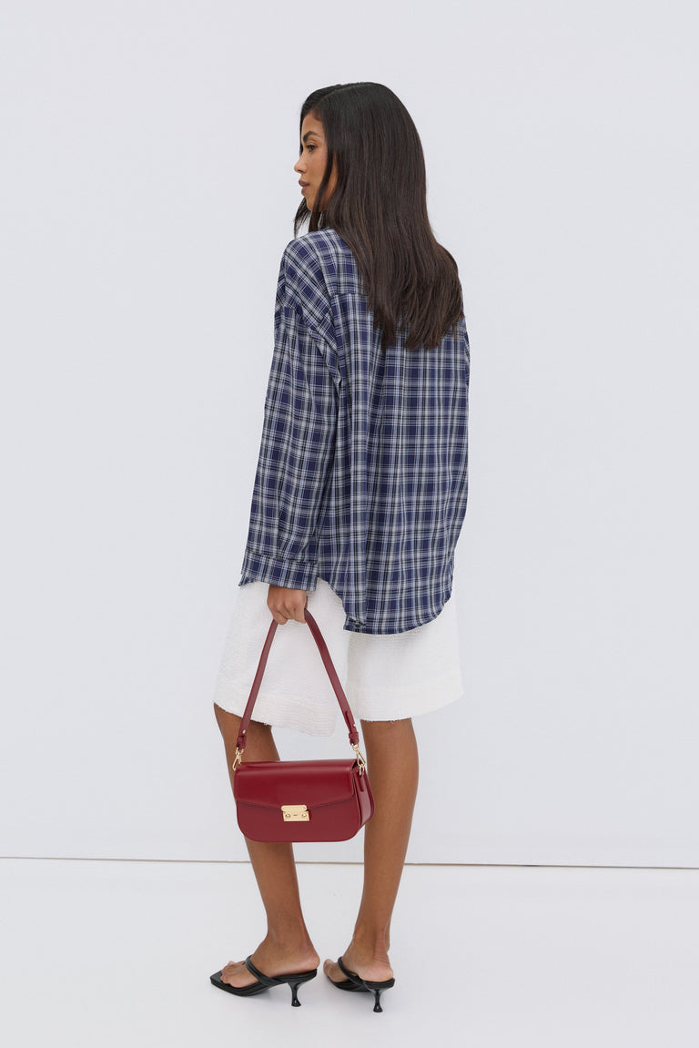 Women's oversized blue checkered button-up shirt.