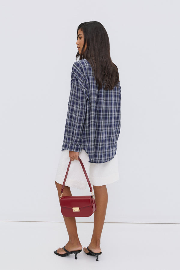 Women's oversized blue checkered button-up shirt.