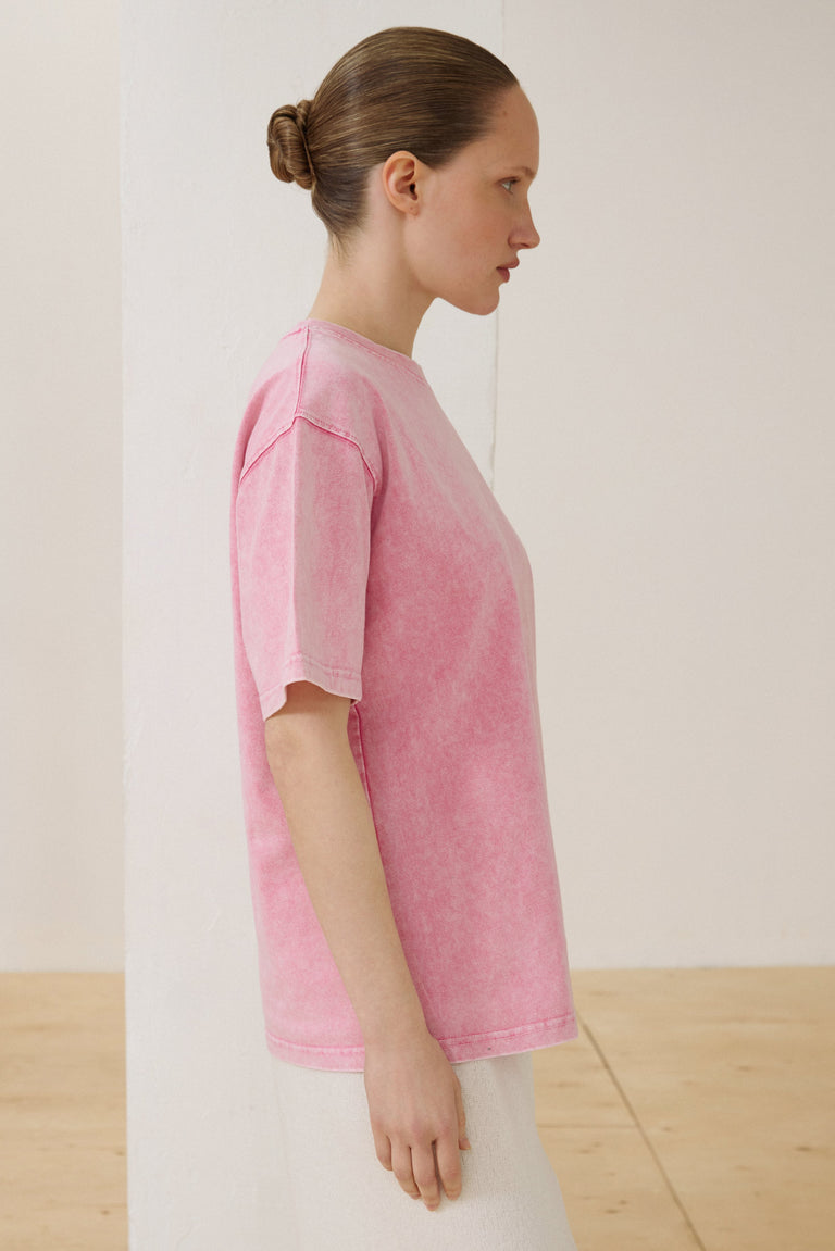 Model wearing pink washed-effect boxy-cut T-shirt.