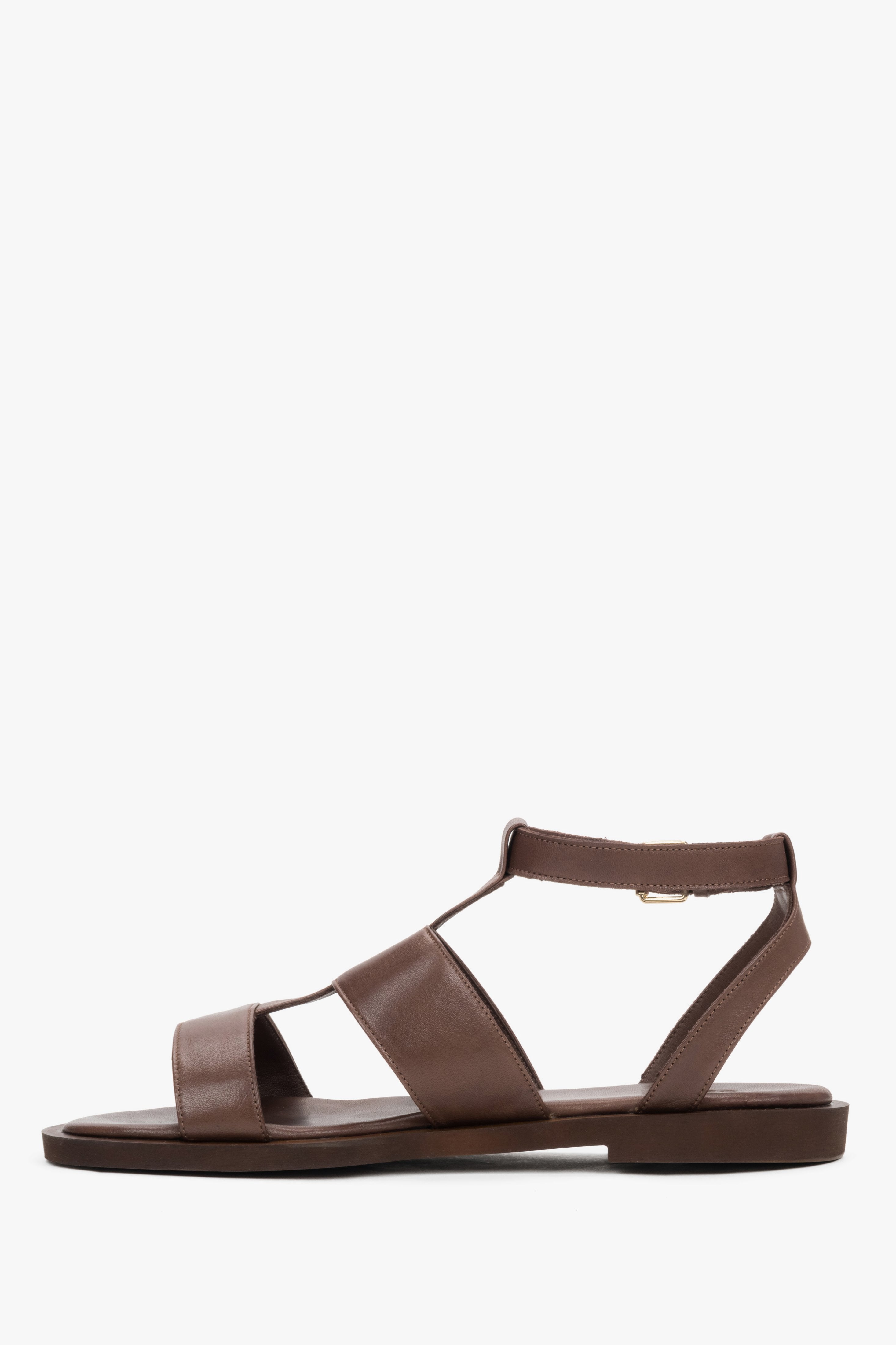 Elegant dark brown leather sandals featuring a flexible lightweight sole and gold buckle.