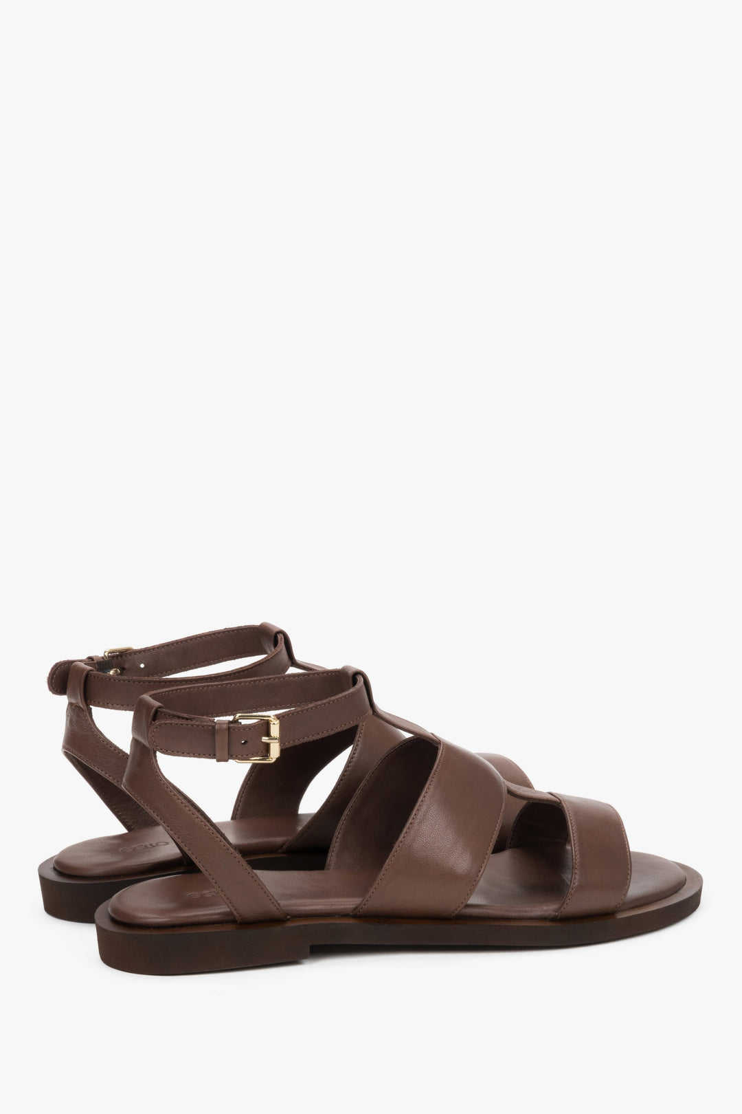 Close-up of the substantial leather straps and gold adjustment buckle on brown sandals.