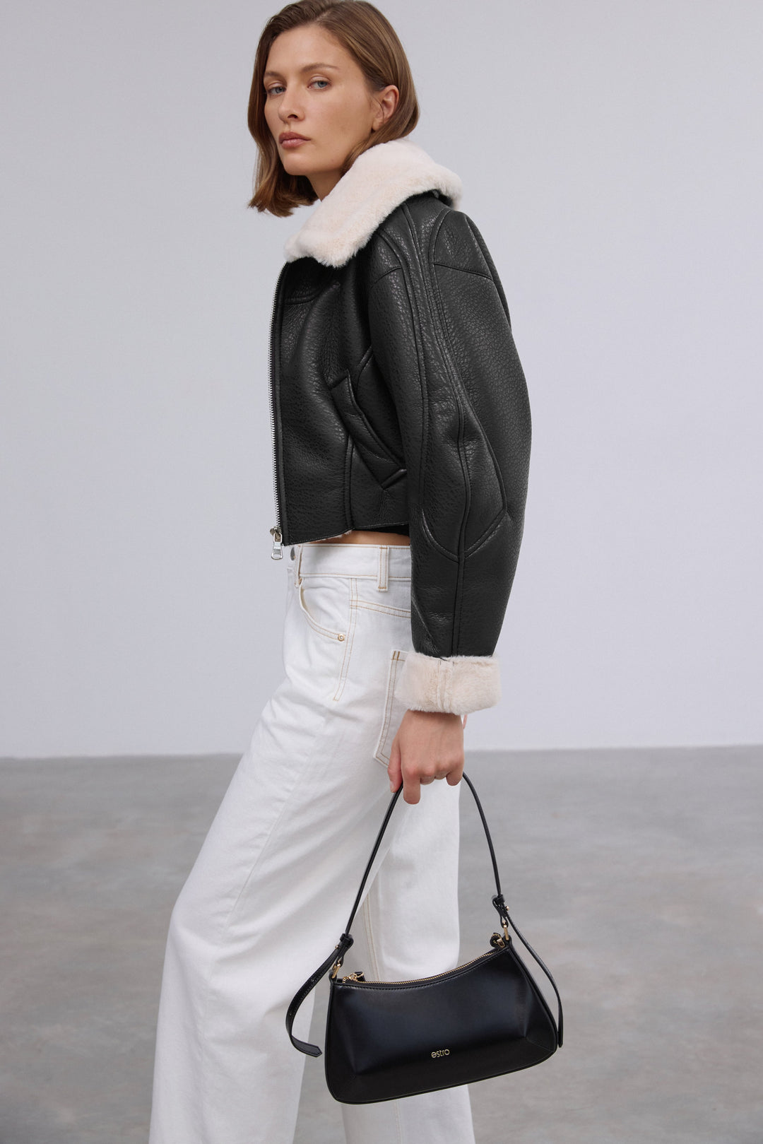 Stylish women's black shearling jacket by Estro made of faux leather and faux fur.