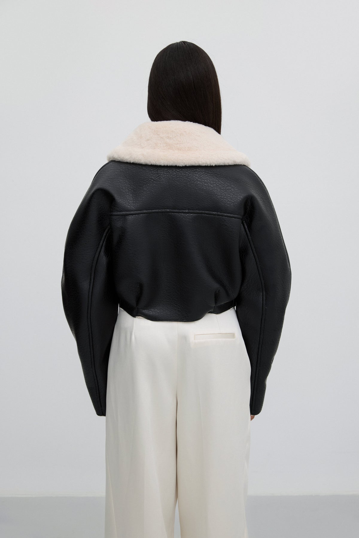Short black jacket with faux fur collar – back view.