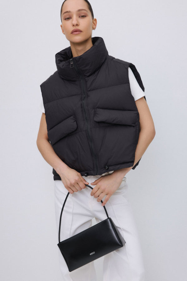 Short black women's puffer vest with zipper.