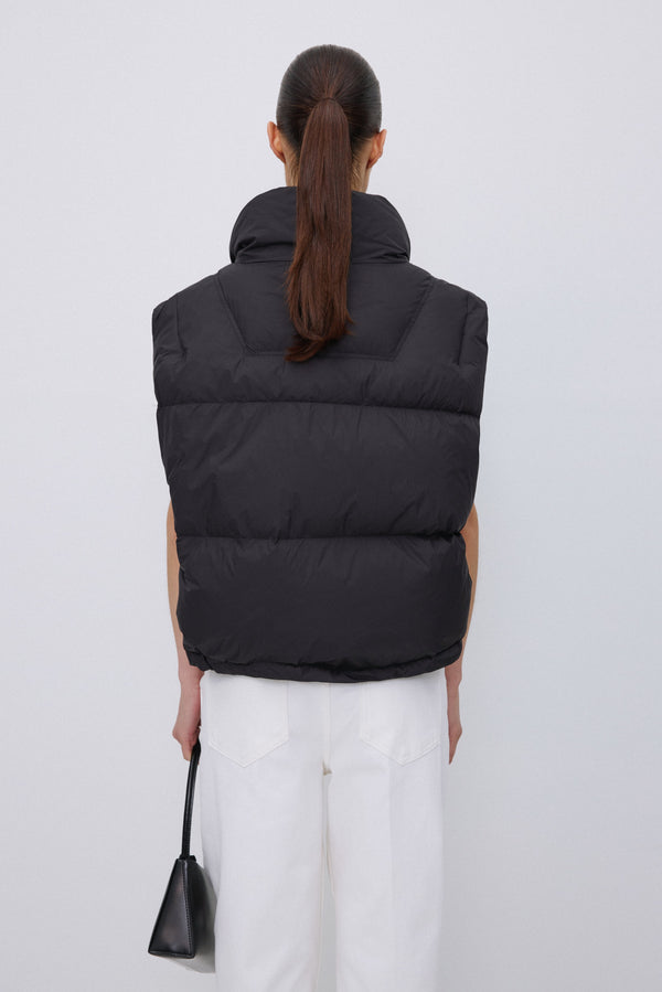Back of women's short black puffer vest.