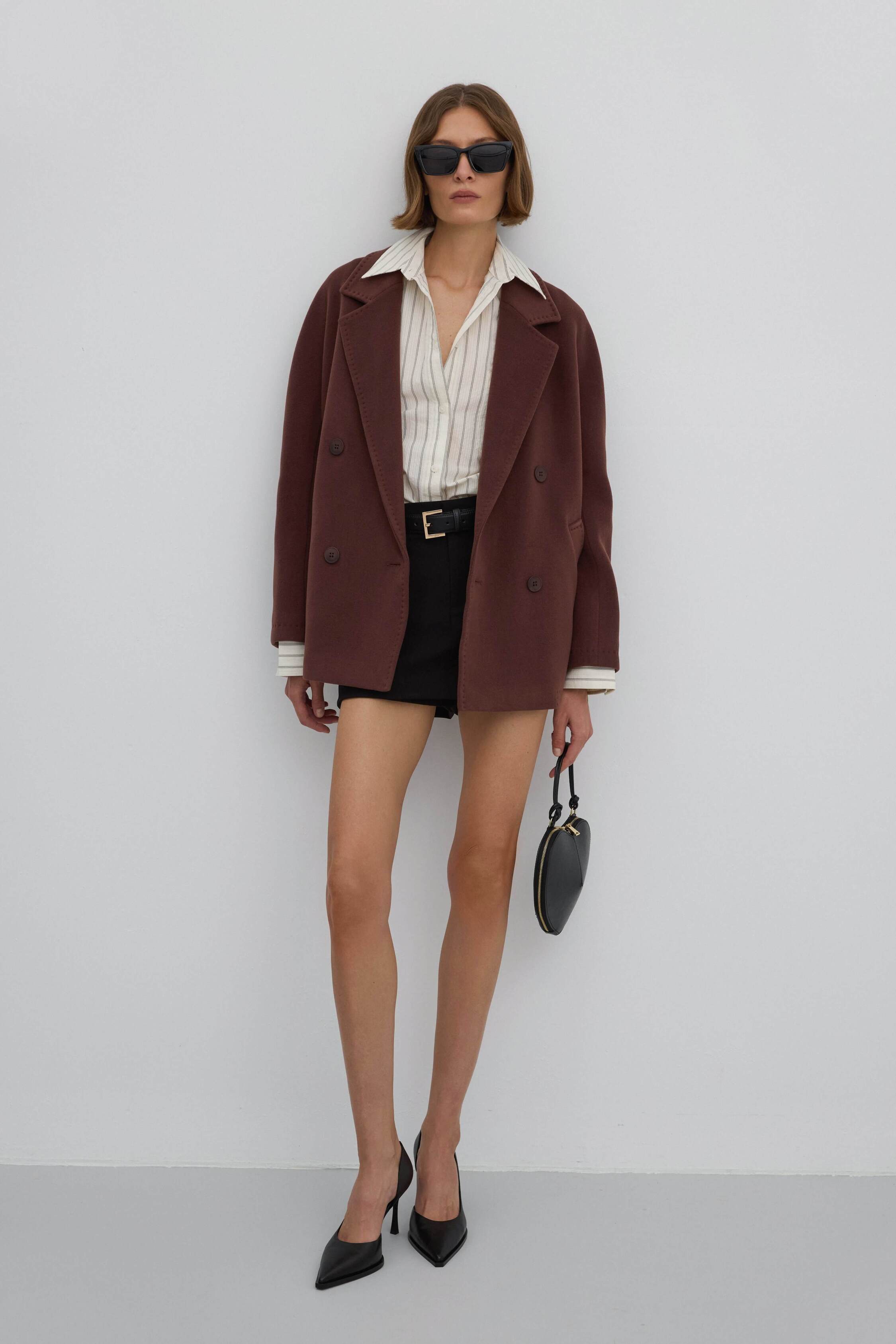 A short, woolen women's coat with a double-breasted design in an elegant dark brown color.