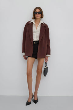 A short, woolen women's coat with a double-breasted design in an elegant dark brown color.