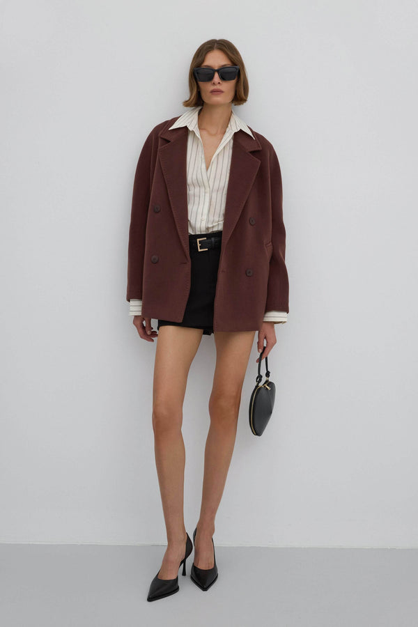 A short, woolen women's coat with a double-breasted design in an elegant dark brown color.