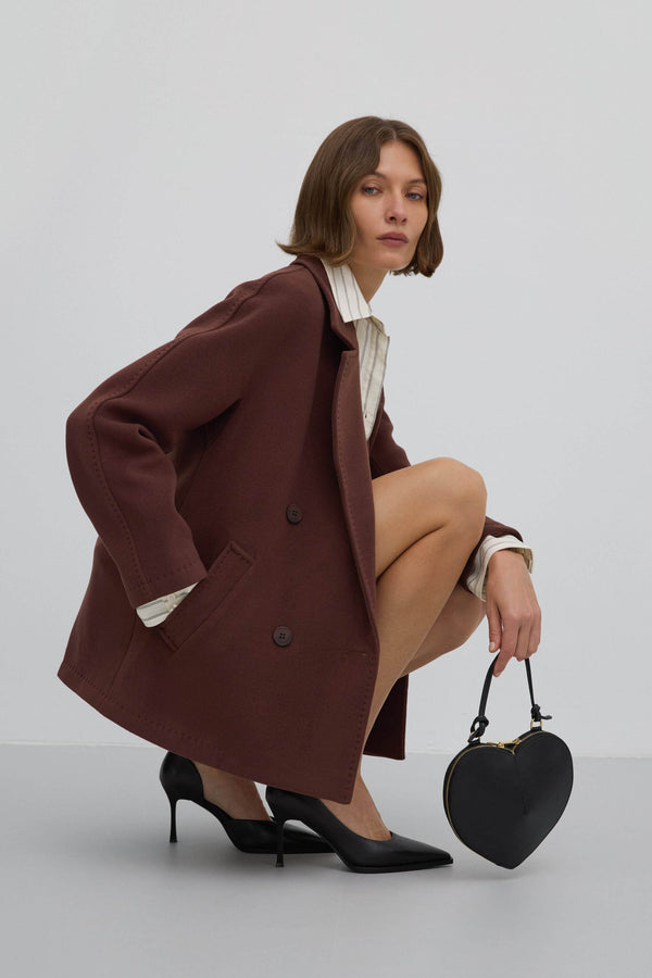 A short, dark brown, double-breasted women's coat made of wool by Estro.