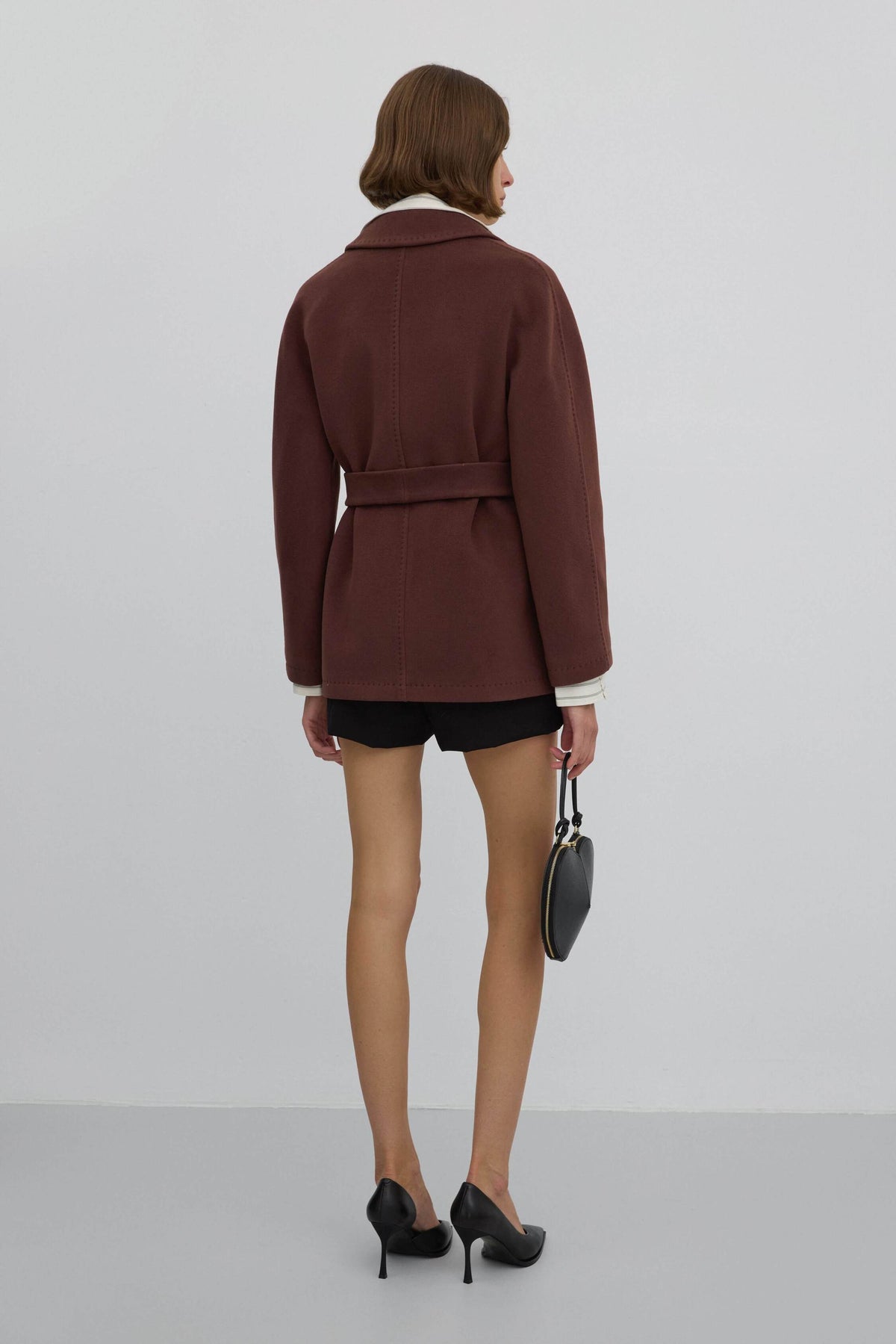 A short, double-breasted women's coat in dark brown Estro.