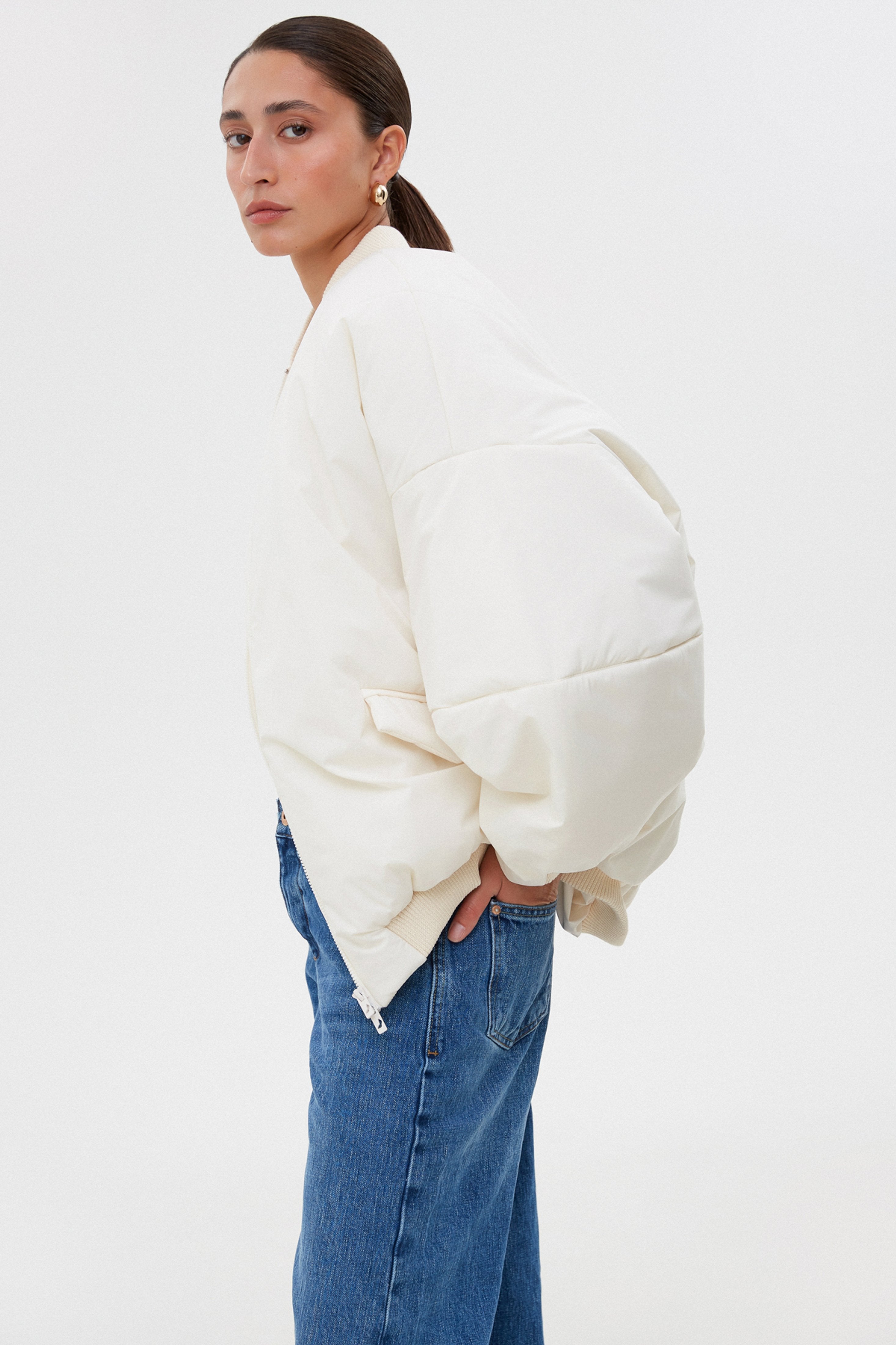 Short milk-white women’s oversize bomber jacket with a stand collar.
