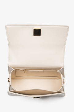 Close-up of the premium natural leather texture and gold-tone accents on a beige bag.