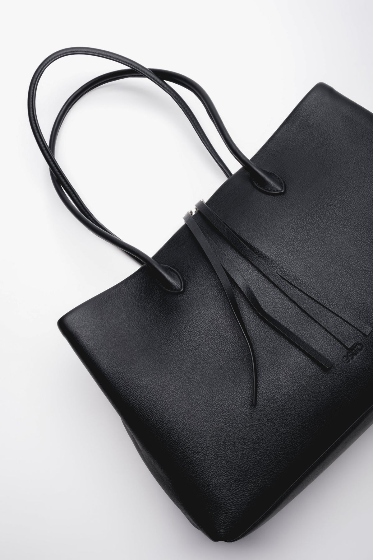 Black leather tote bag with a stylish drawstring puller at the zippers. Functionality and elegance in one.
