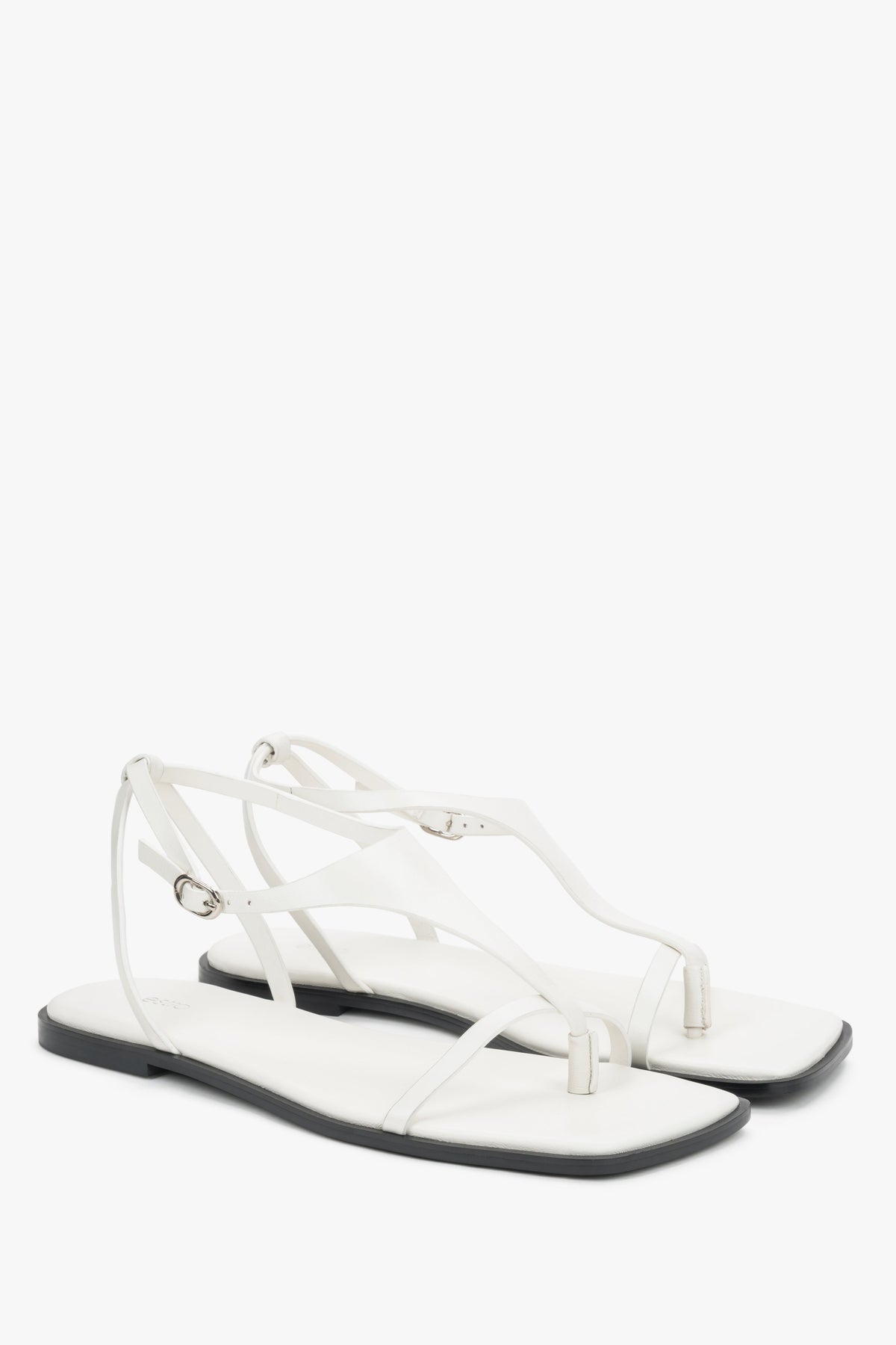 White flat sandals with a square toe and a toe-post strap.