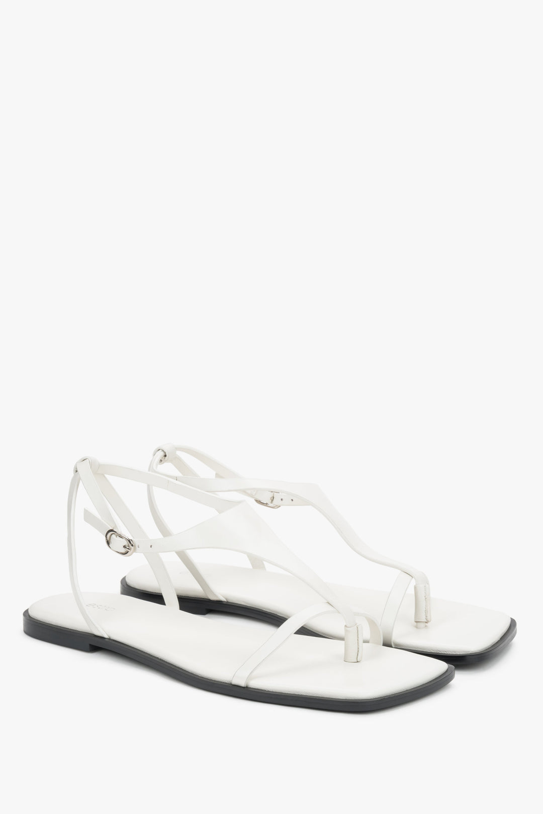 White flat sandals with a square toe and a toe-post strap.