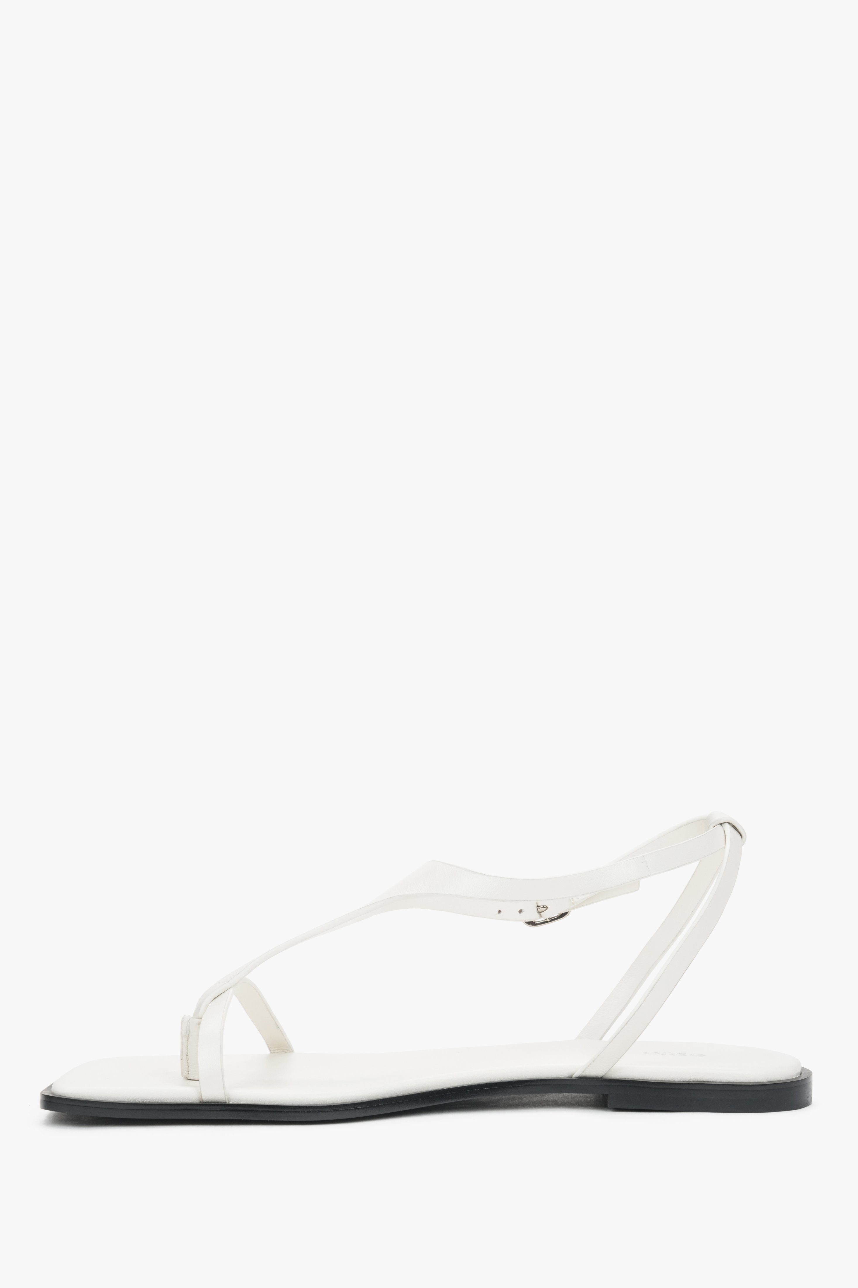 Women’s white flat sandals with a square toe and toe-post strap by Estro – side view.