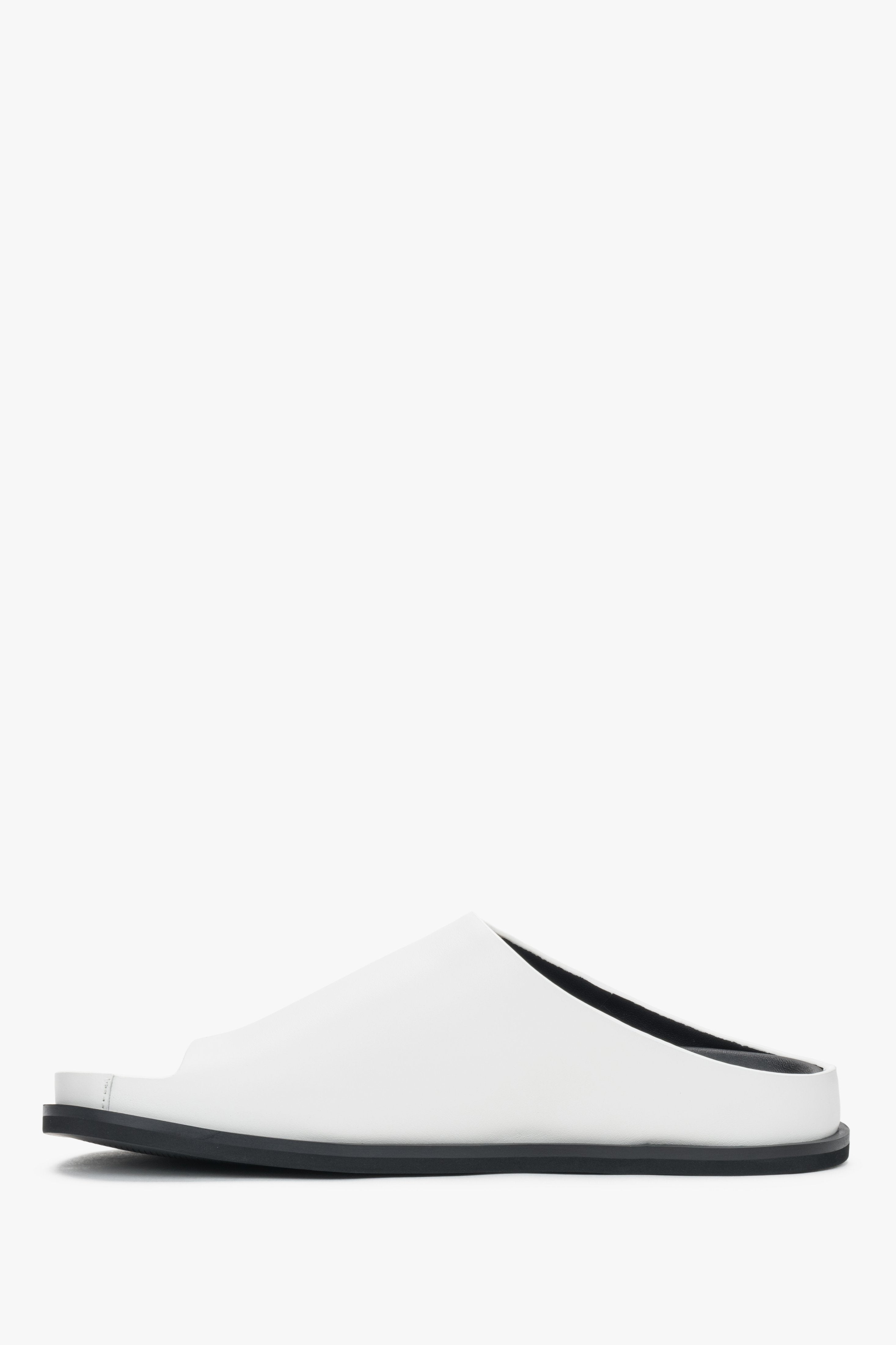 White women’s leather slide sandals on a flat sole.