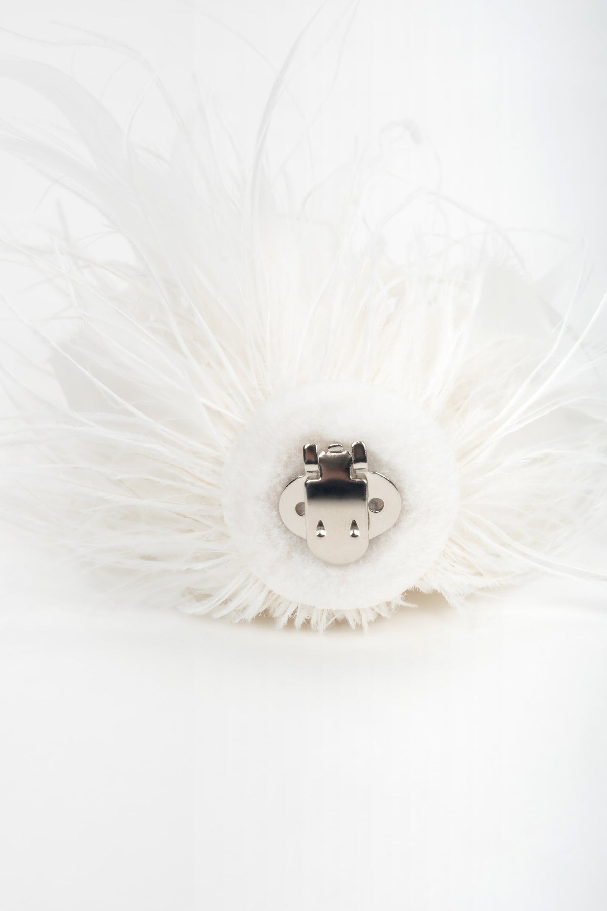 Detail view of white feather trim on women's high heel sandals