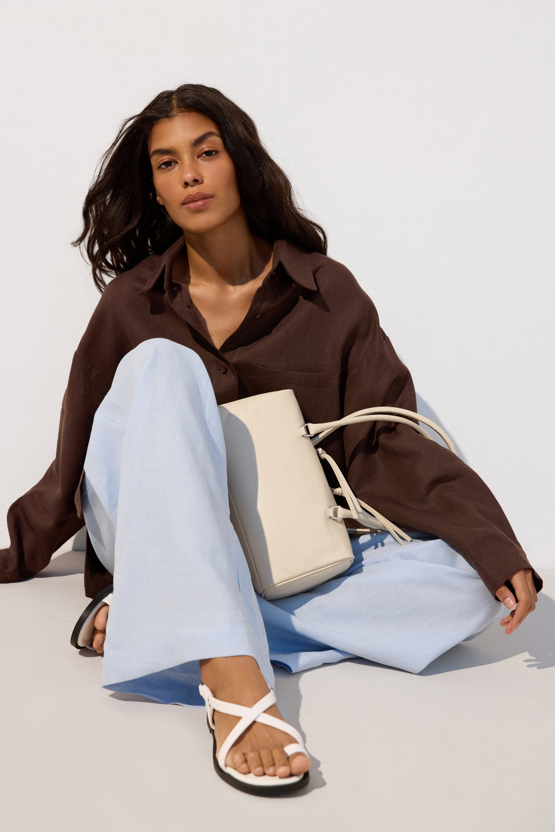 Women’s white leather flat sandals – presentation on a model.