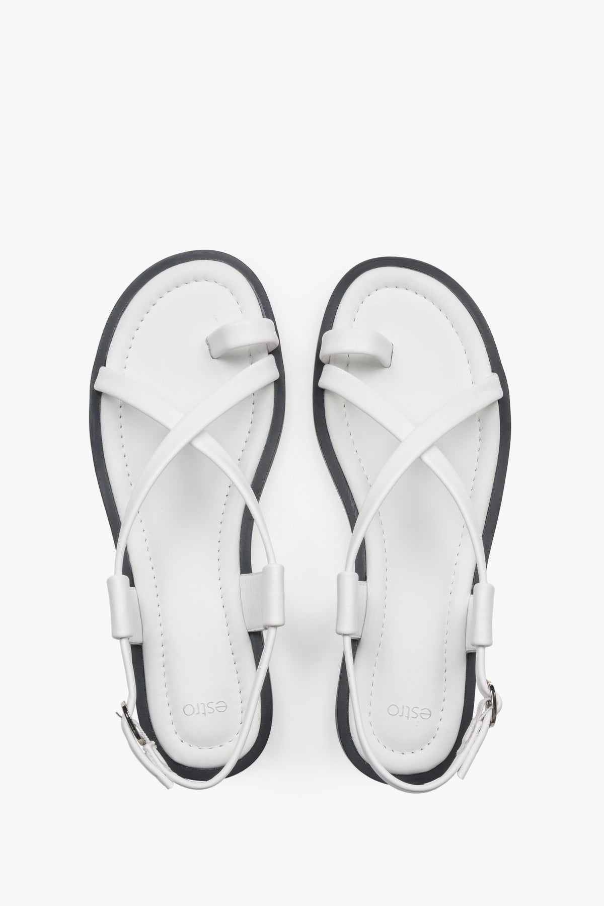 White women’s leather sandals by Estro on a flat sole with a toe loop.