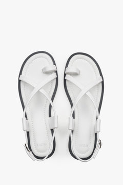 White women’s leather sandals by Estro on a flat sole with a toe loop.