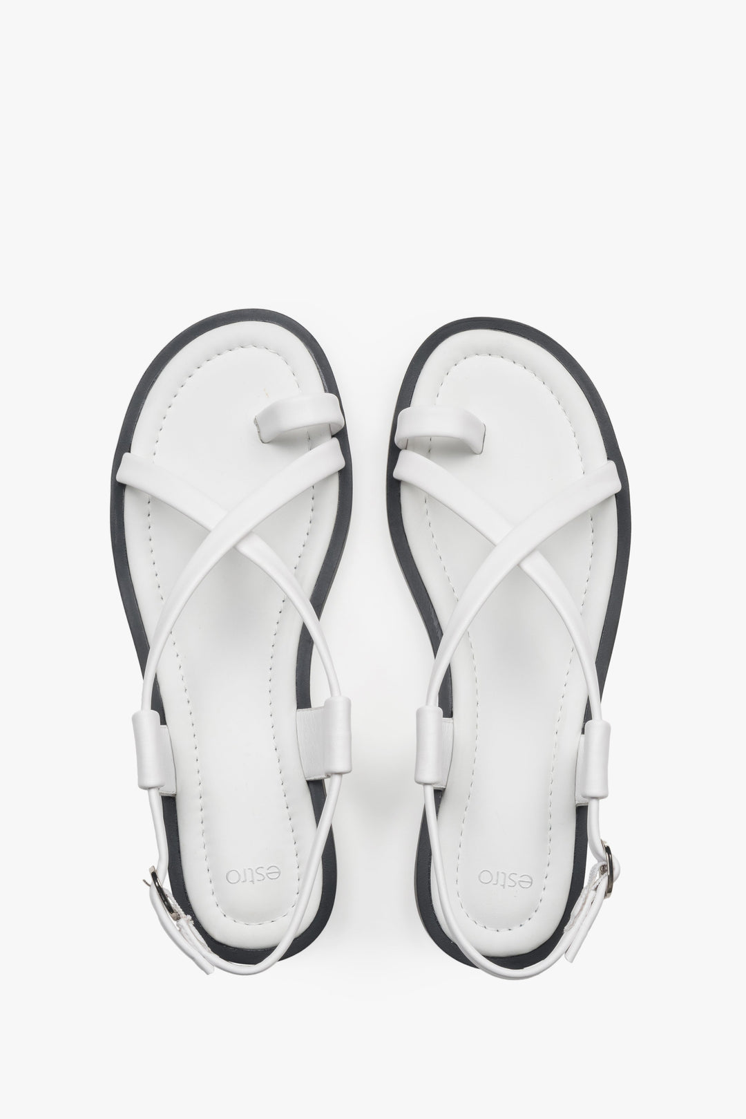 White women’s leather sandals by Estro on a flat sole with a toe loop.