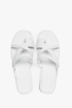 Women's minimalist white leather slide sandals with soft interwoven straps.