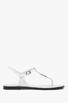 White leather women’s flip-flop sandals with a flat sole.