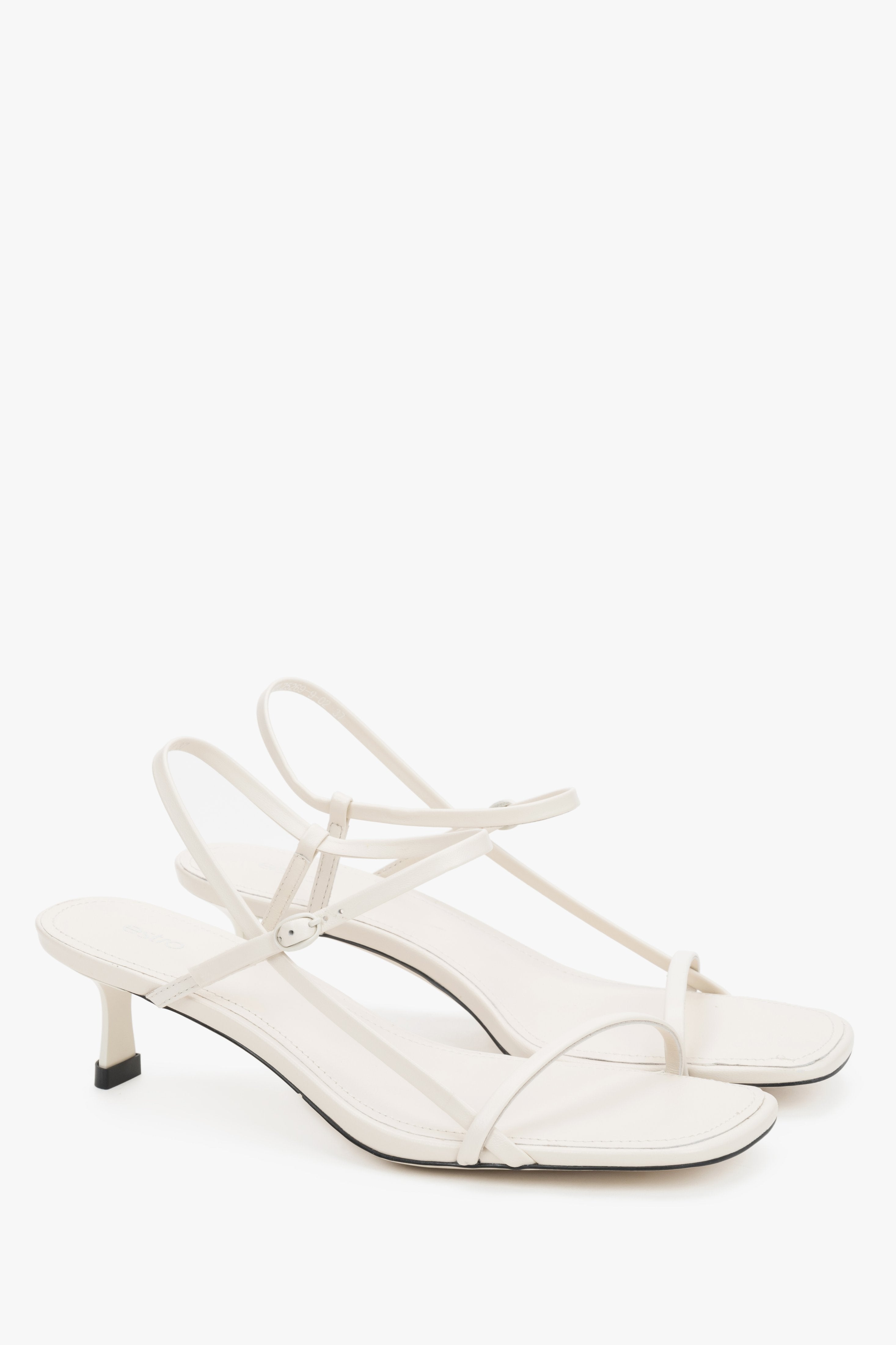 Women’s white leather low-heel sandals by Estro with thin straps.